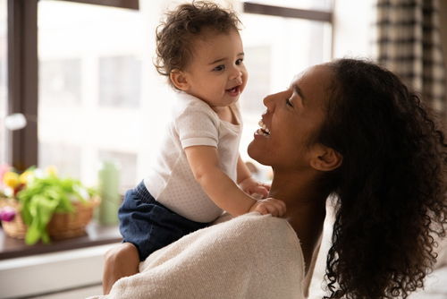 Close,Up,Smiling,African,American,Woman,Hugging,Adorable,Little,Daughter,
